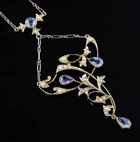 An Edwardian 15ct gold, aquamarine and seed pearl set foliate drop necklace with two colour gold chain,